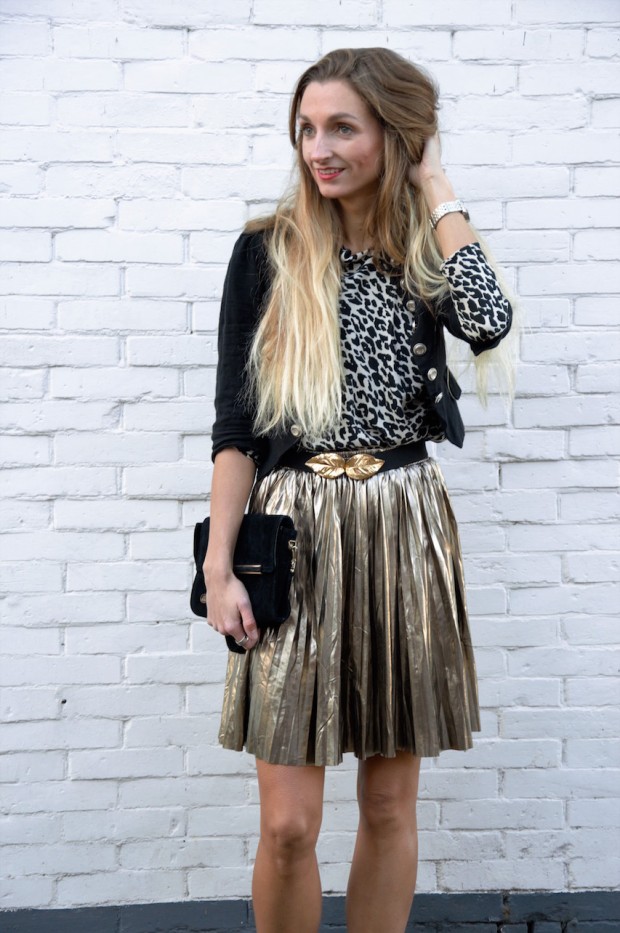 Woman wearing a gold pleated skirt with a black top