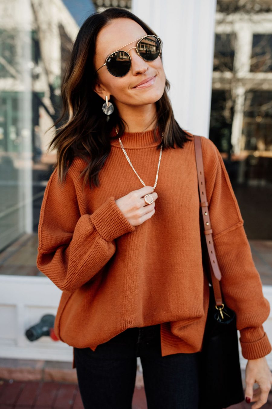 Woman wearing a burnt orange knit sweater with jeans