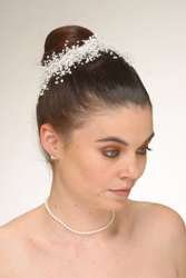 High ballerina bun encircled by a pearl headband
