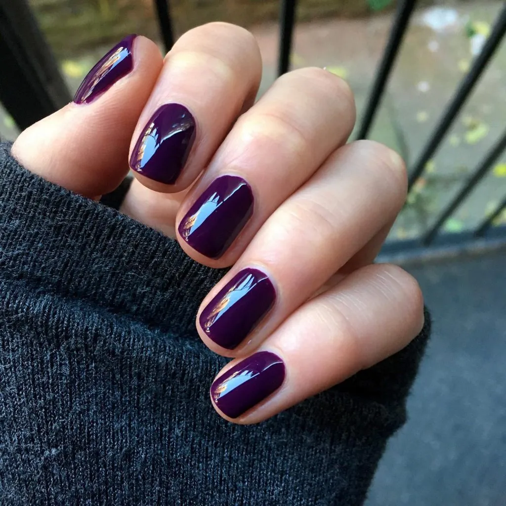Short dusty plum nails with a soft satin finish