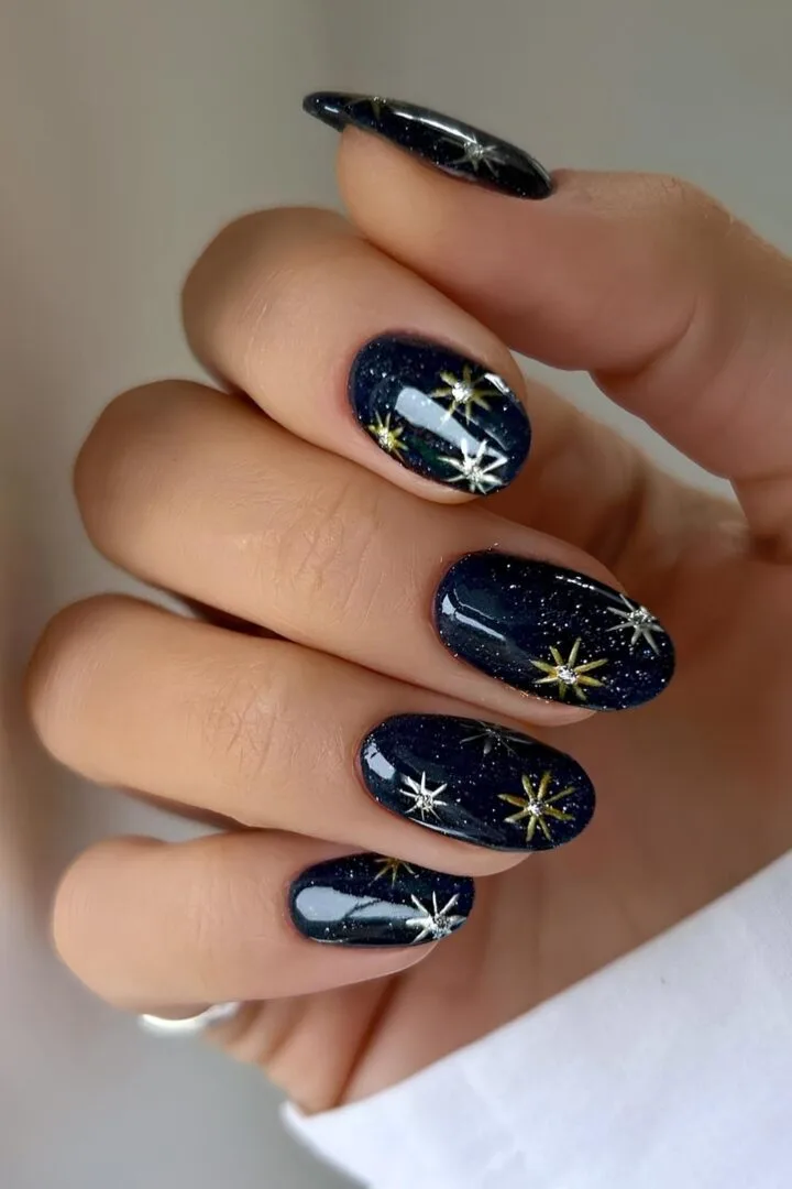 Midnight Navy with Gold Starbursts: dark blue short oval nails with gold and silver starbursts