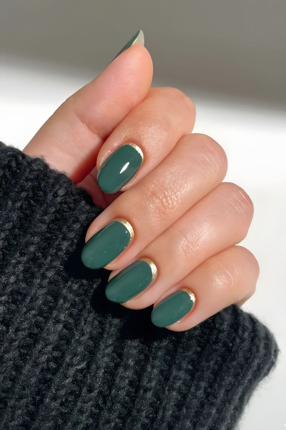 Dark green manicure with gold accent details