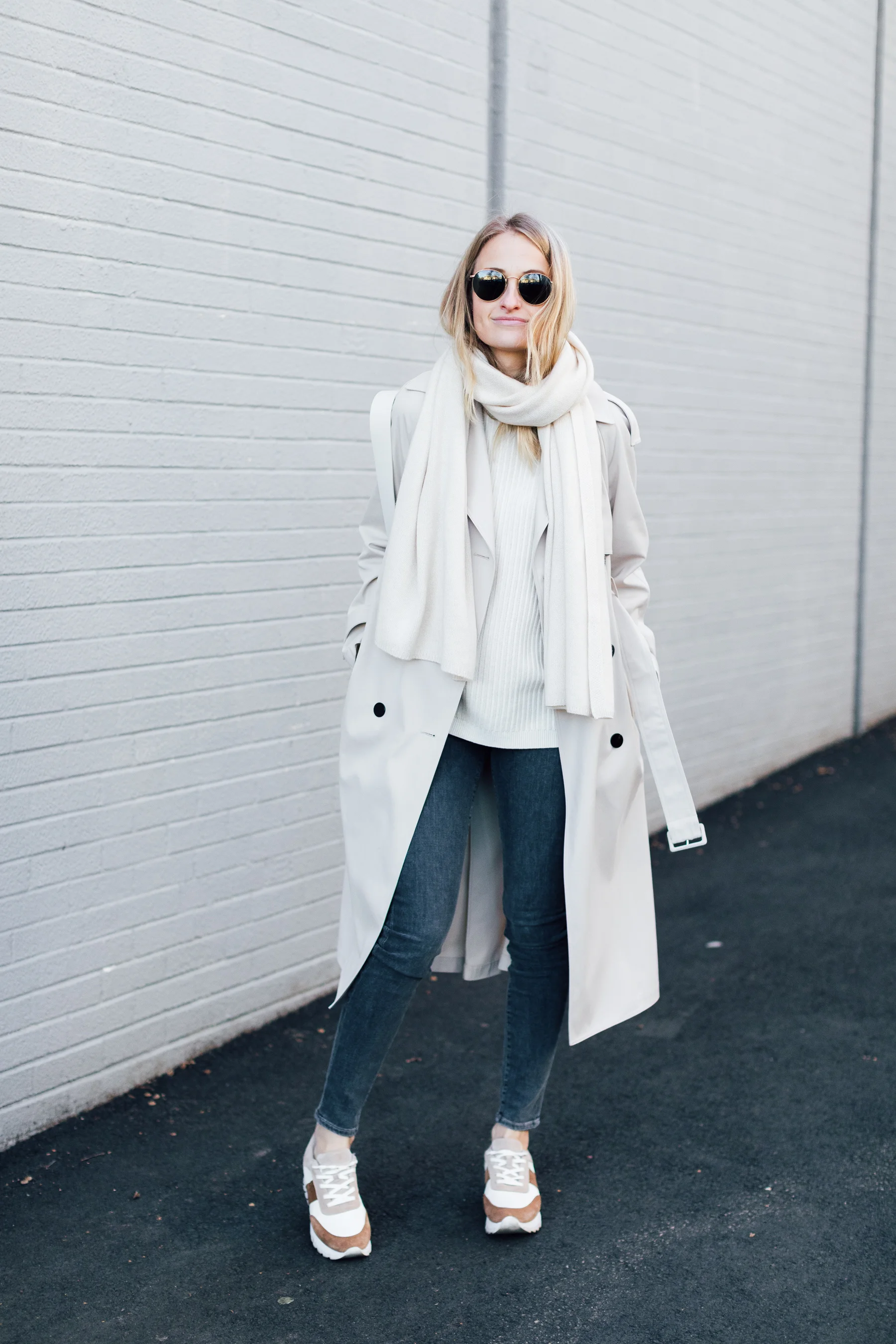 Woman wearing a trench coat with a scarf, winter street style