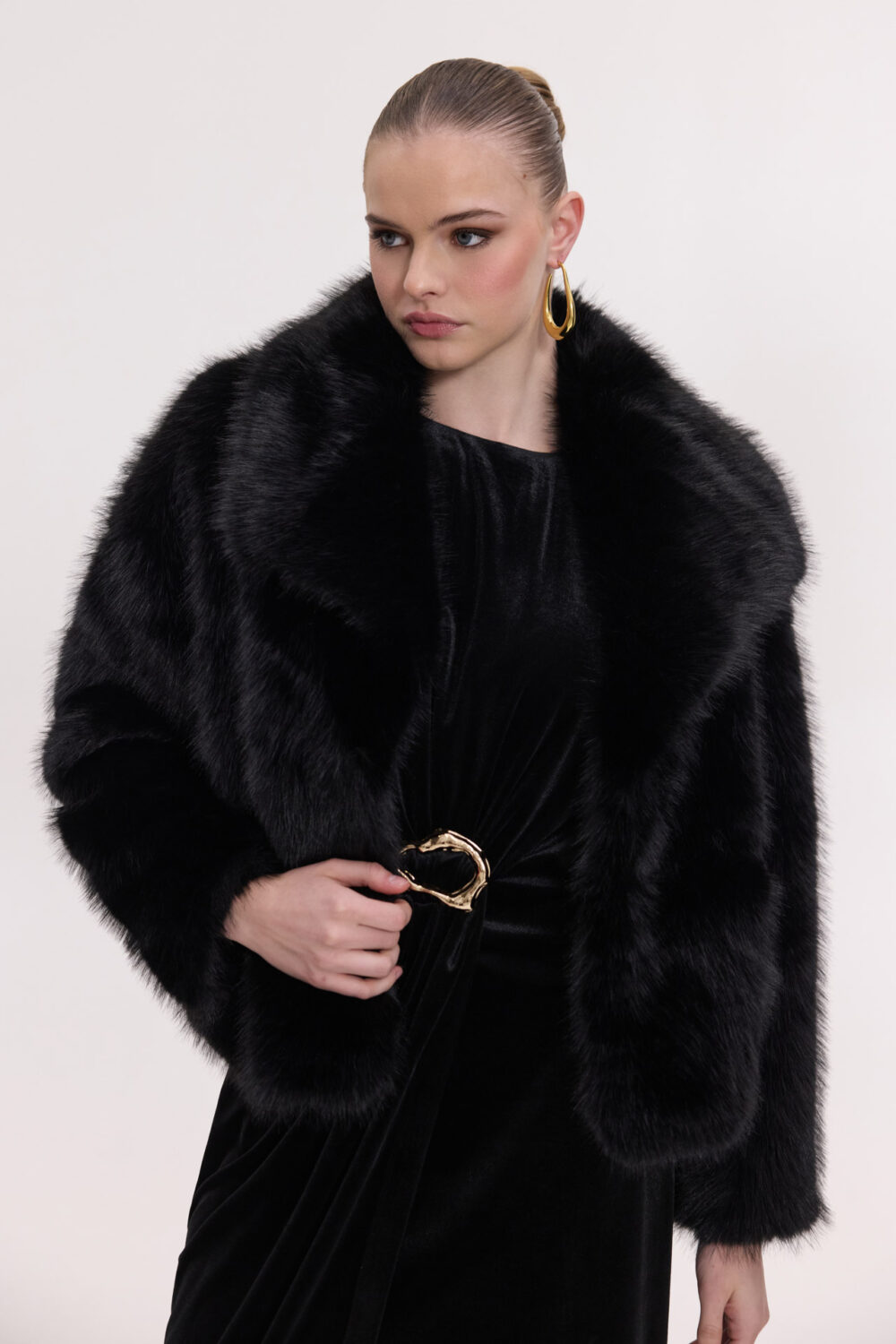 Faux fur coat styled with a velvet skirt for a winter evening look