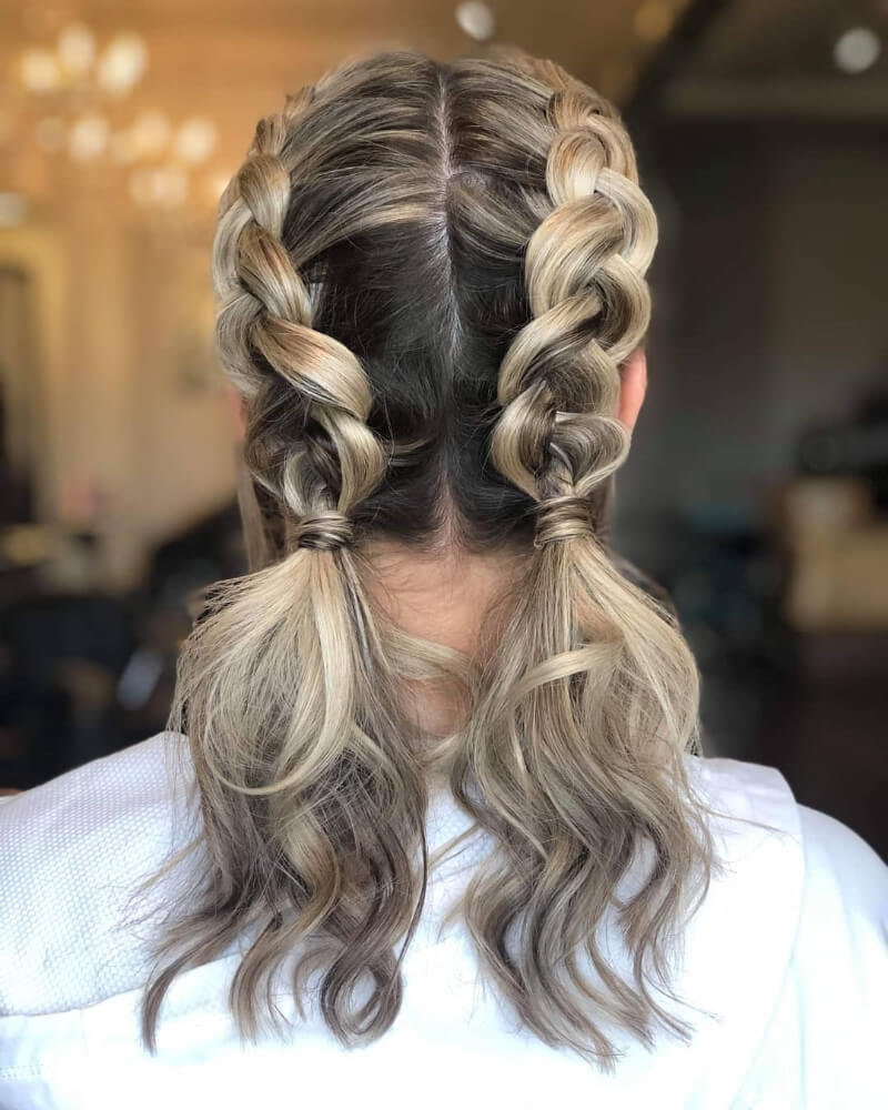 Twin Dutch braids into a half-up ponytail