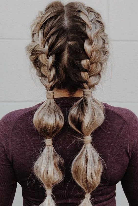 Woman with low double bubble braids made with small elastics