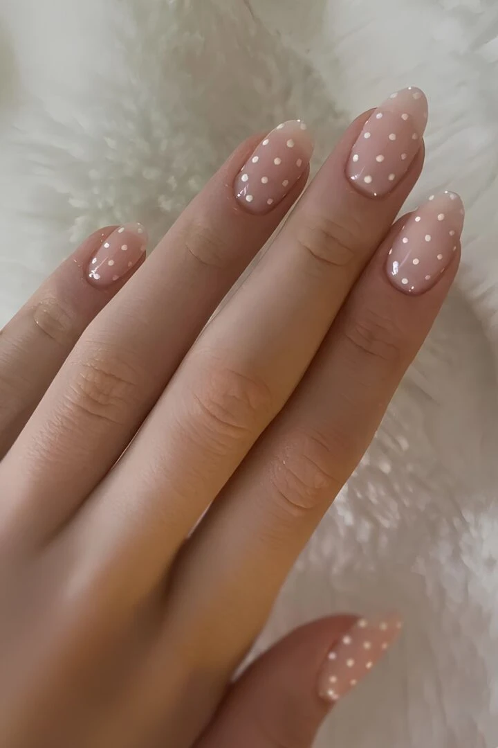 Sheer nude-pink nails with tiny white dot details