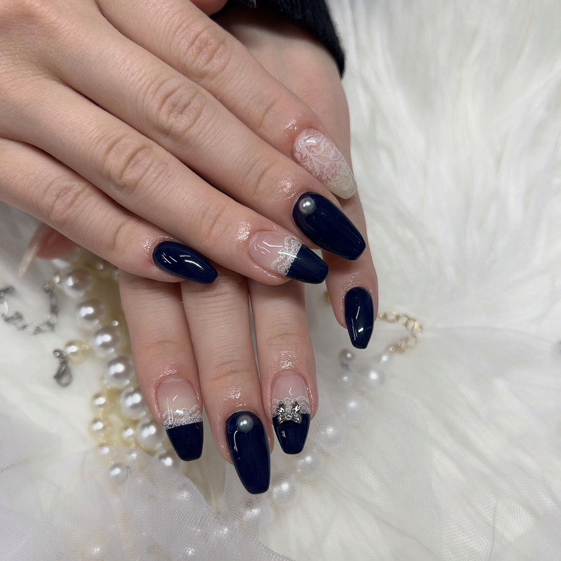 Almond navy nails with pearl studs and lace French accents