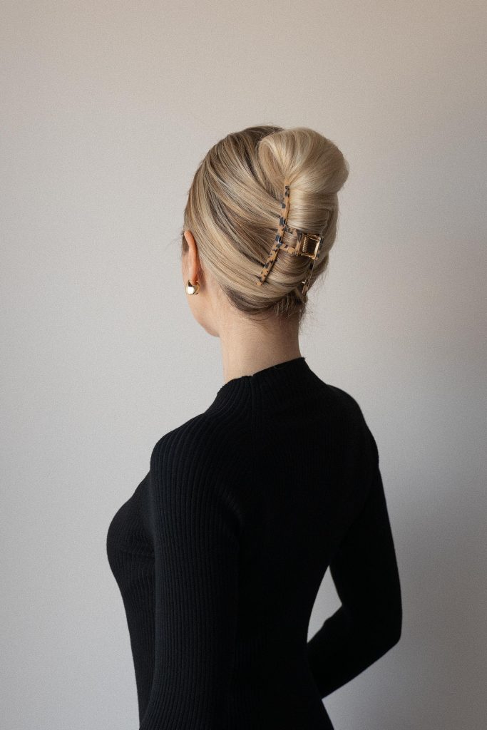 Medium-length highlighted hair twisted up and held with a claw clip
