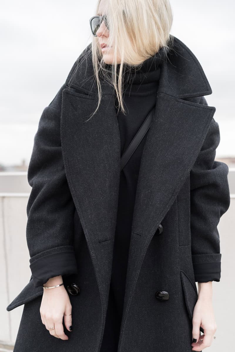 Woman in oversized charcoal wool coat and black turtleneck