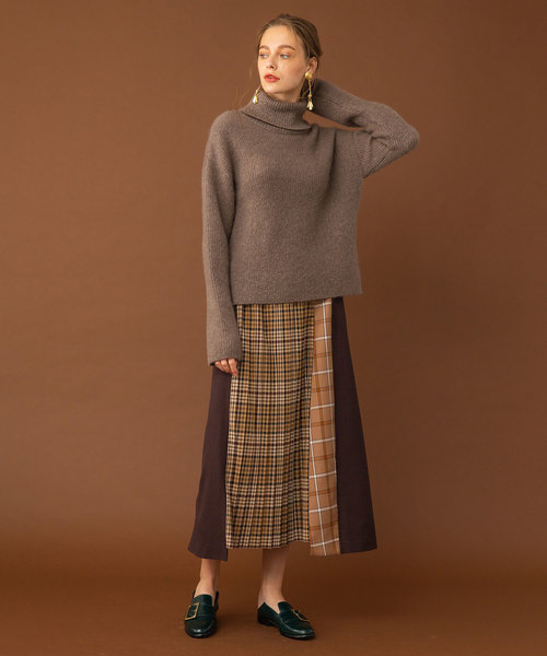 Oversized taupe turtleneck sweater with patchwork plaid midi skirt and black loafers
