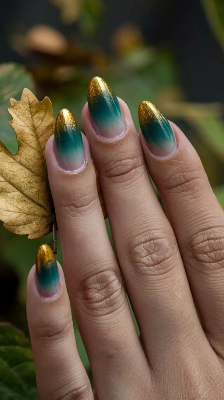 Almond nails fading from deep forest green at the base into gold-glitter tips