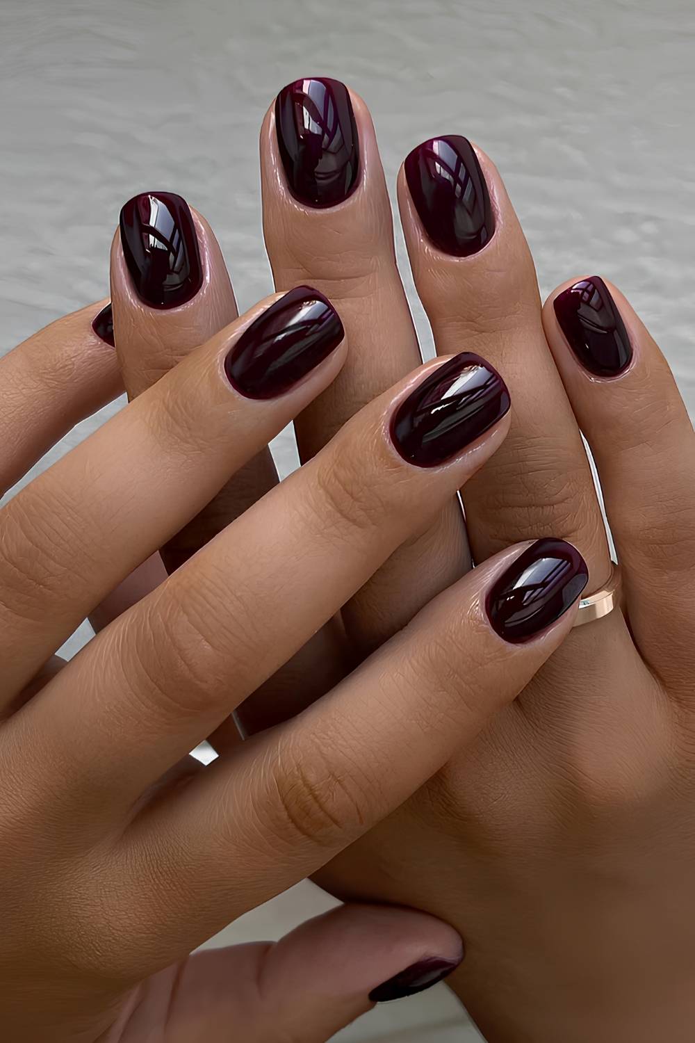 Glossy deep black-cherry nails on short squoval nails