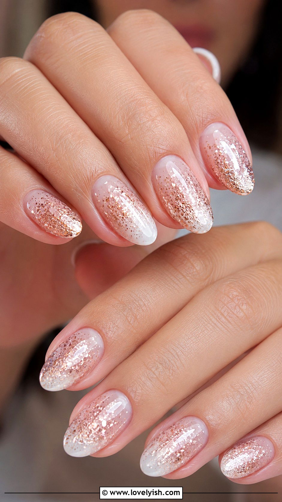 Rose gold glitter ombre fading into a nude base on almond nails