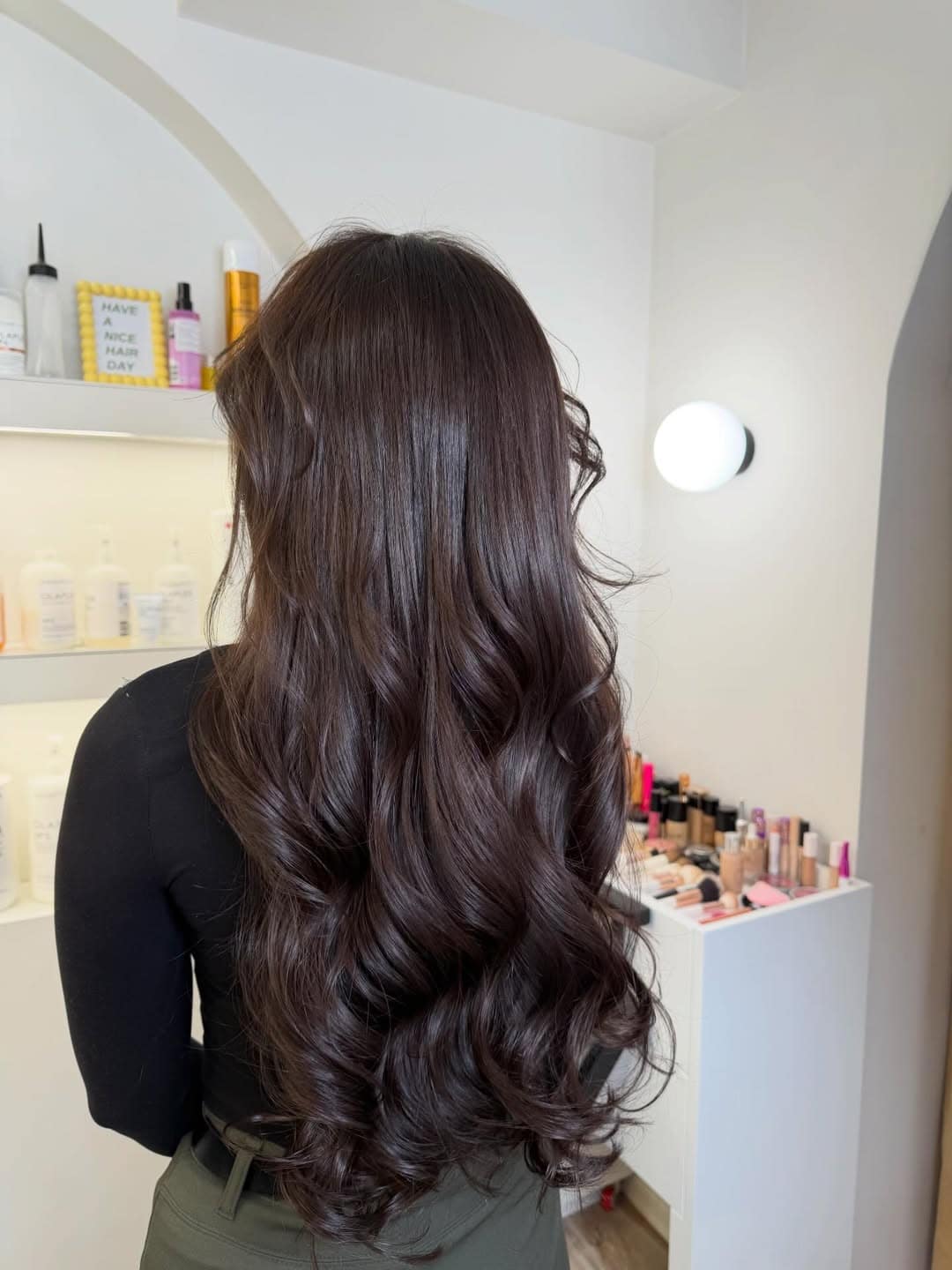 Back view of long glossy espresso brown curls with rich depth and shine