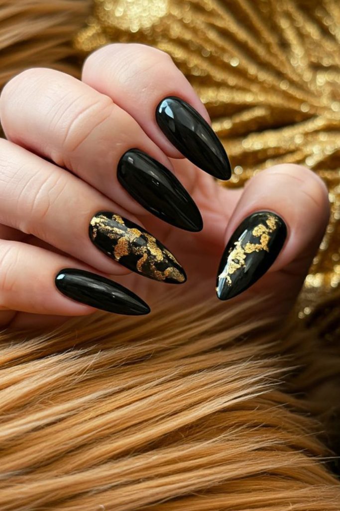 Black stiletto nails with gold foil accent nails