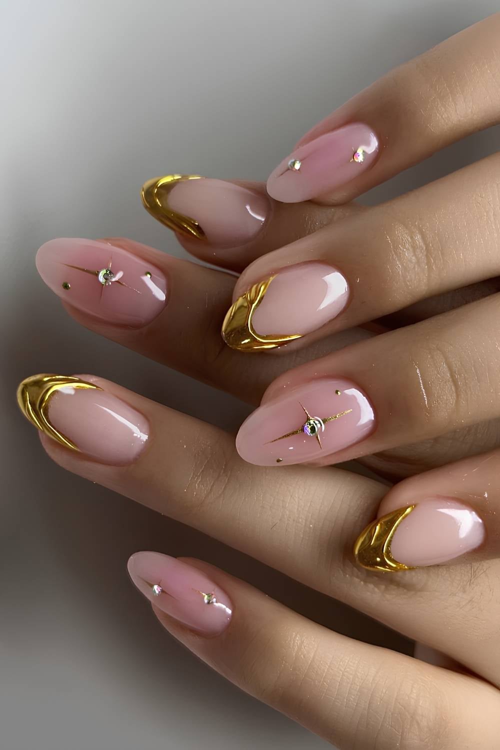 Gold chrome French tips with crystal starbursts on sheer pink nails