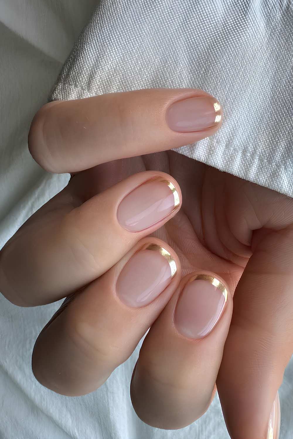 Gold micro French tip manicure on short nude nails