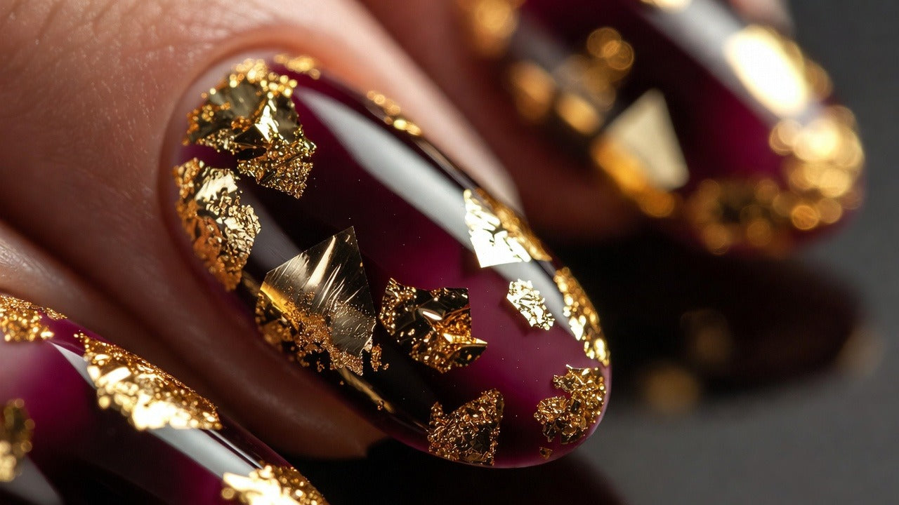 Deep plum nails with chunky gold foil flakes