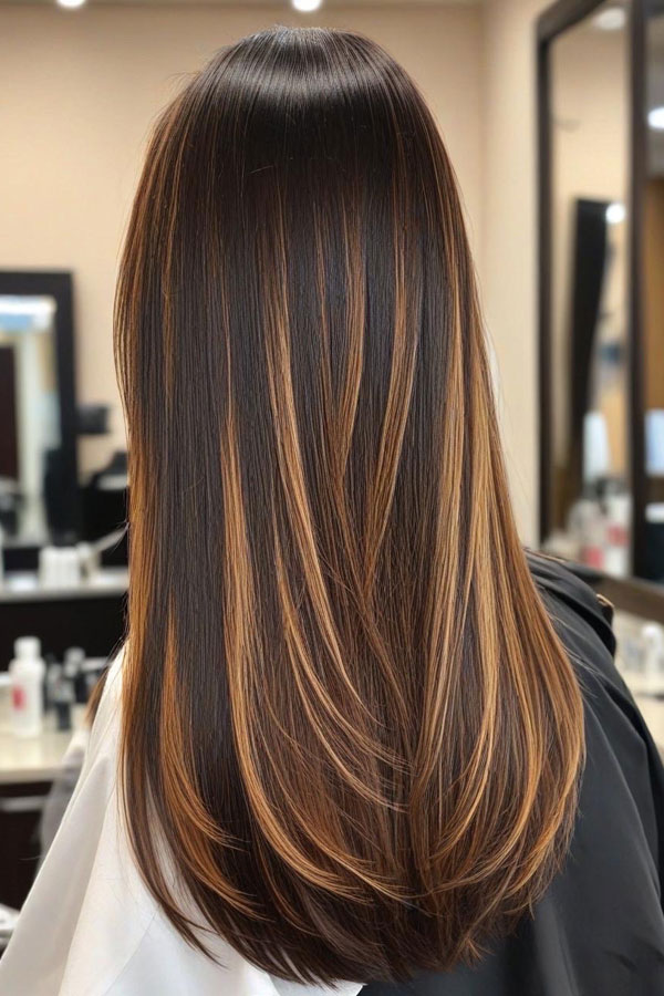 Back view of long straight espresso hair with golden face-framing highlights