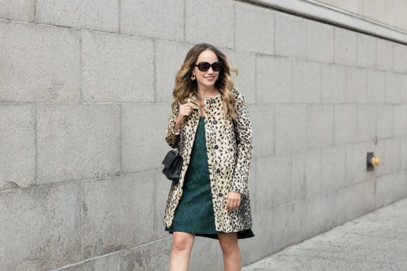 Leopard print coat worn over a dark green dress with a black handbag