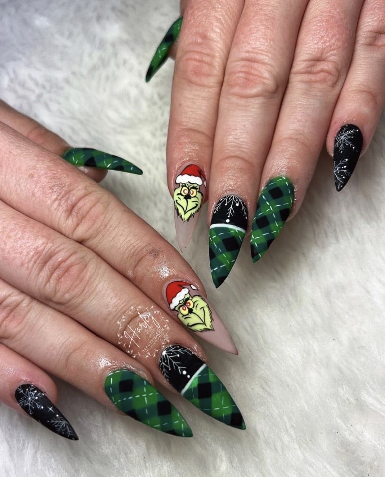 Medium square nails with a Grinch in a Santa hat and red plaid nail art