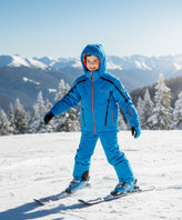 A child wearing a bright ski suit with reflective trim for winter sports