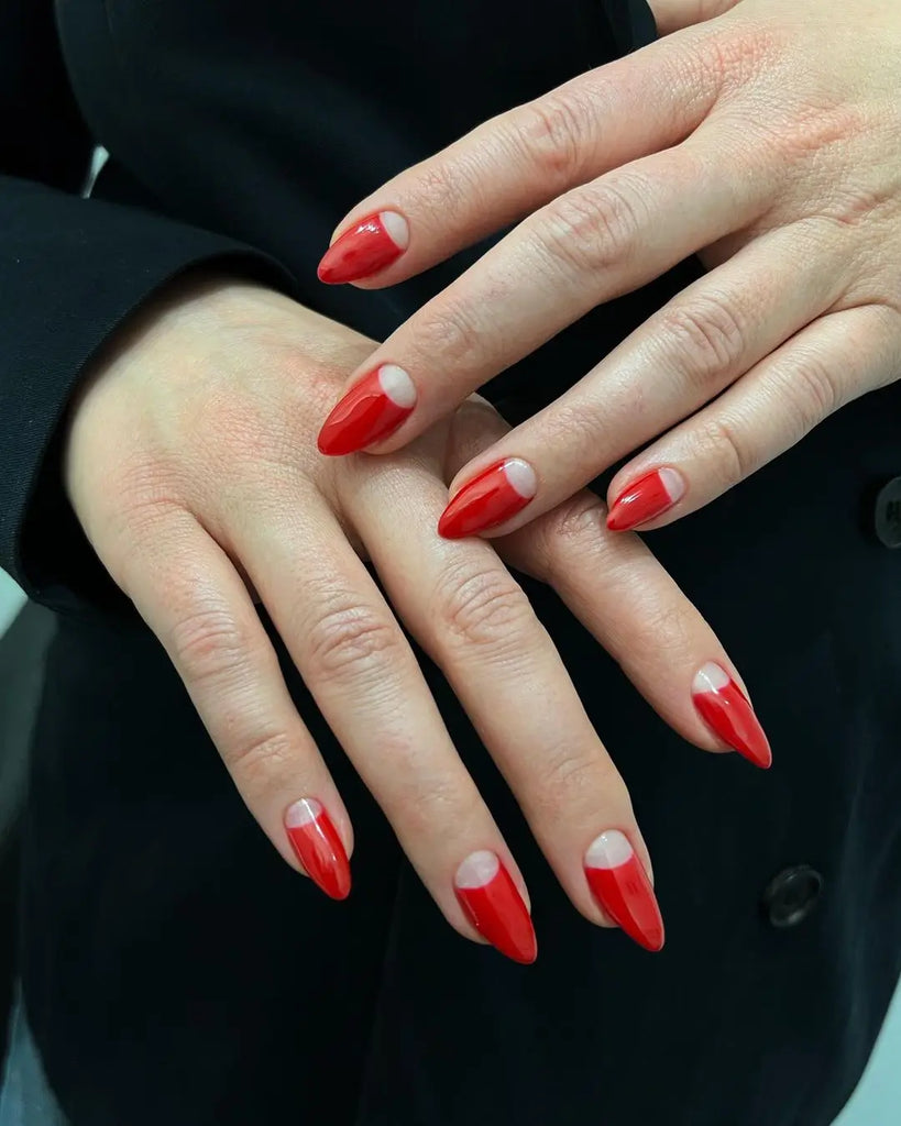 Red reverse French half-moon nails on short oval nails