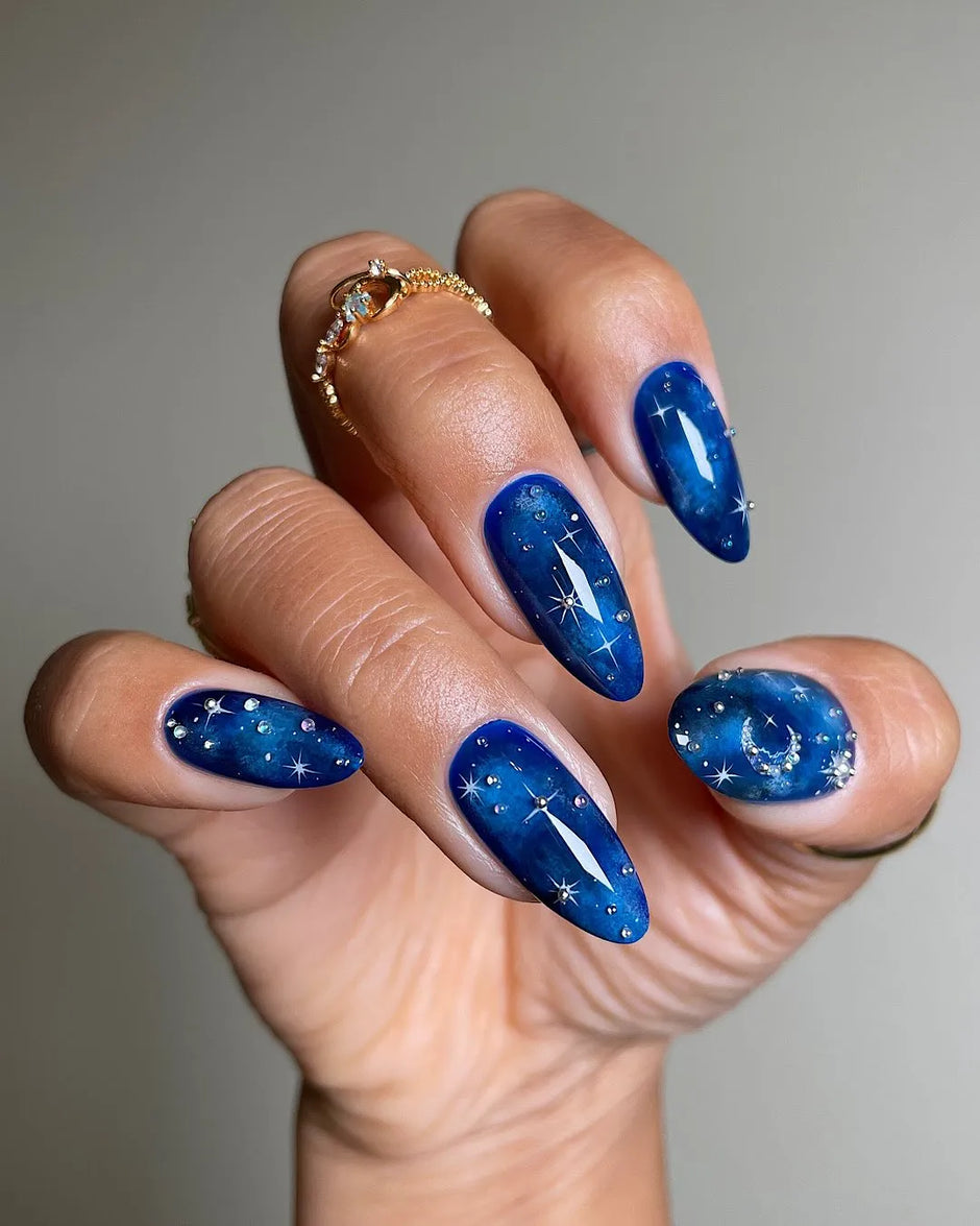 Deep blue galaxy nails with star accents