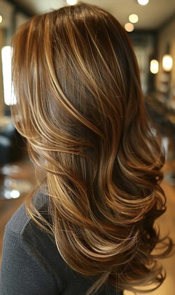 Honey hazelnut balayage on brunette hair with soft waves