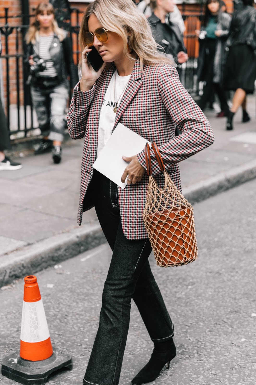 Woman wearing a brown plaid wool blazer with black jeans and booties street style