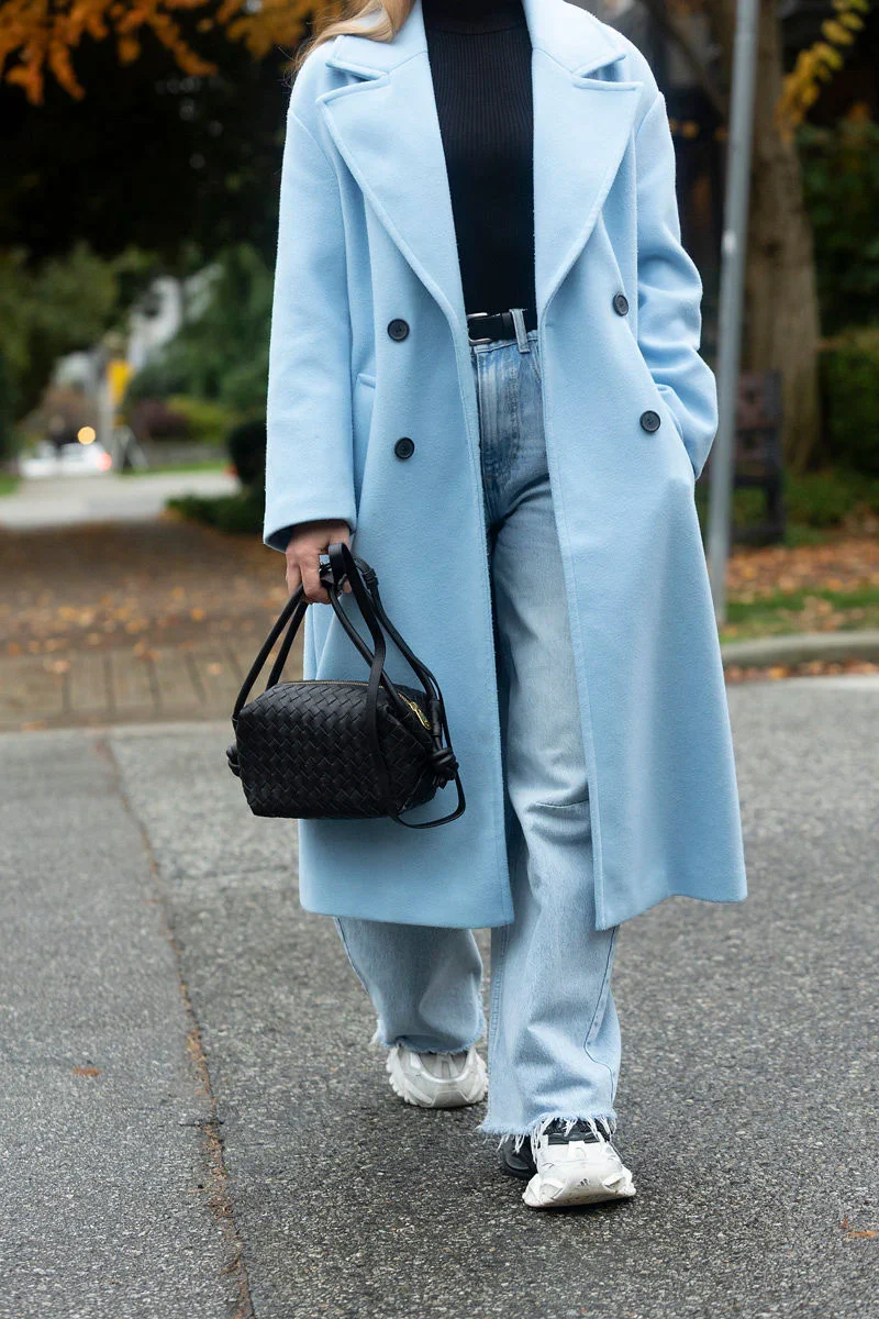 Woman wearing a pastel blue car coat