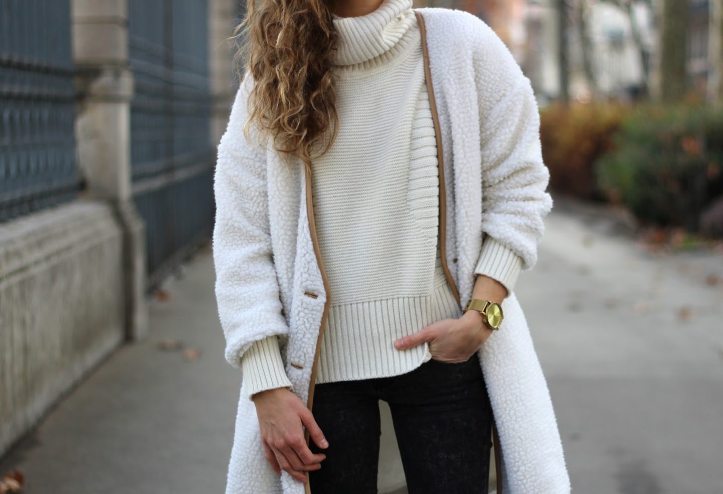 Cream teddy coat over a cream turtleneck knit with black pants