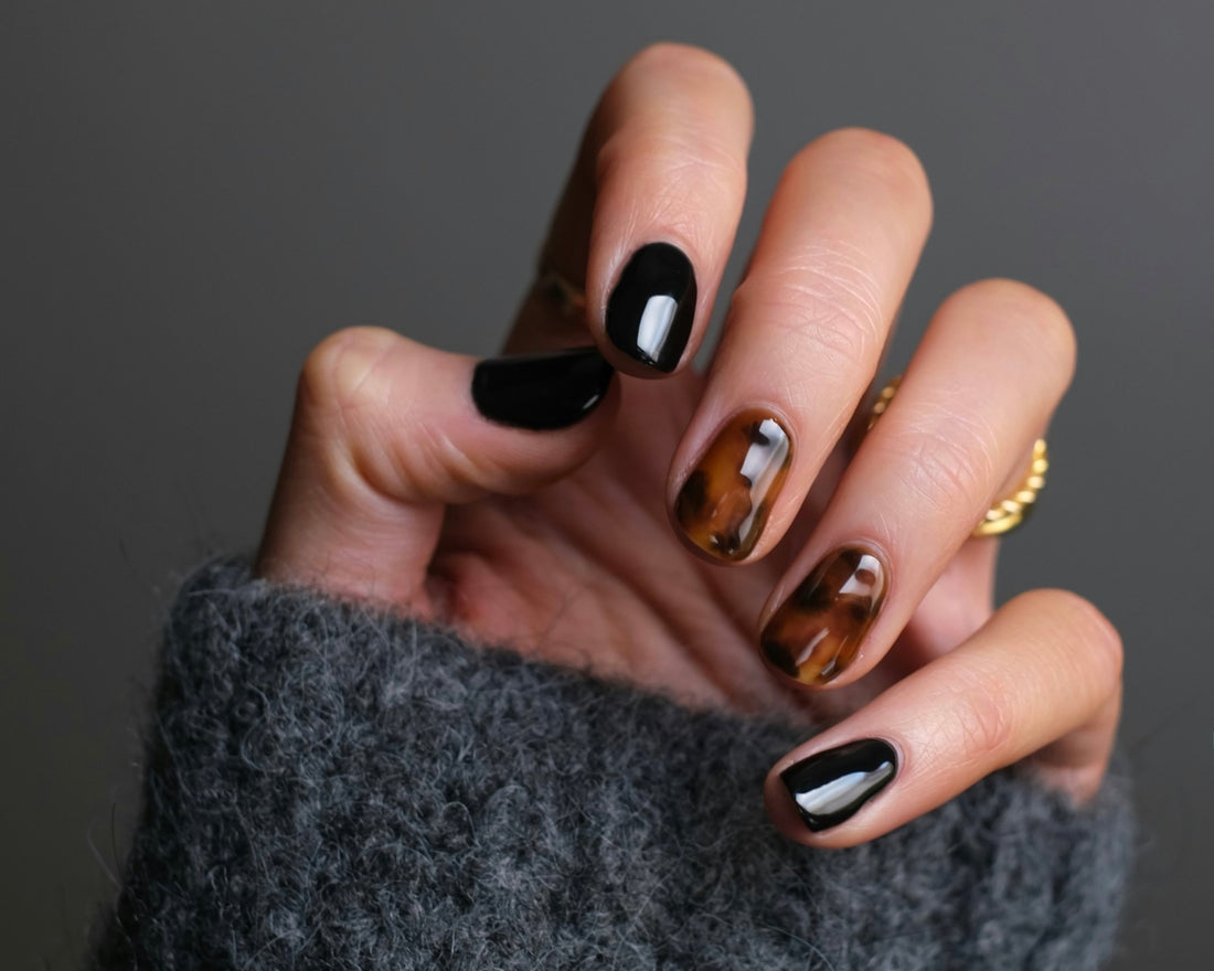 Short nails with black polish and tortoiseshell accent nails