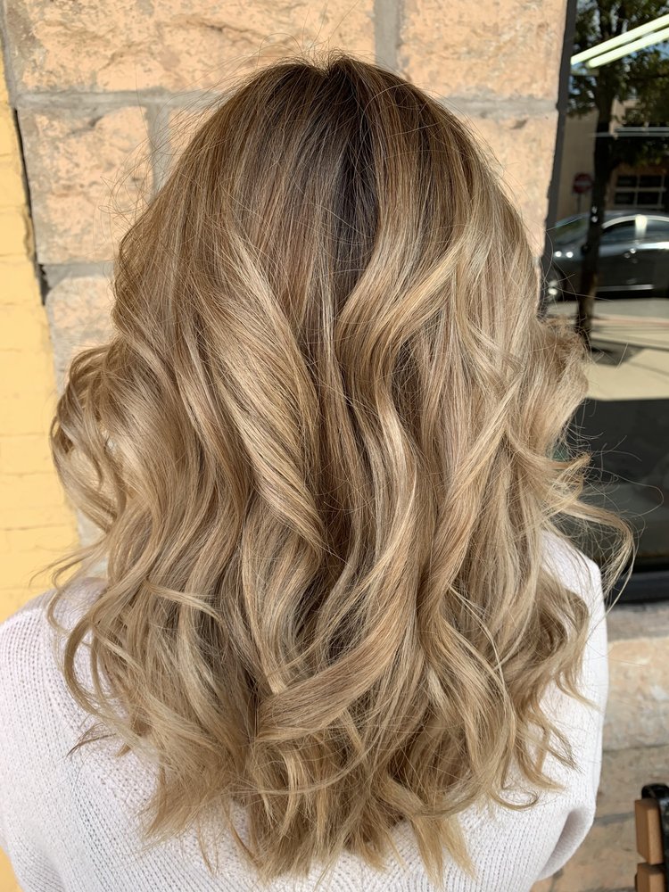 Soft curls in buttery blonde hair with chestnut lowlights