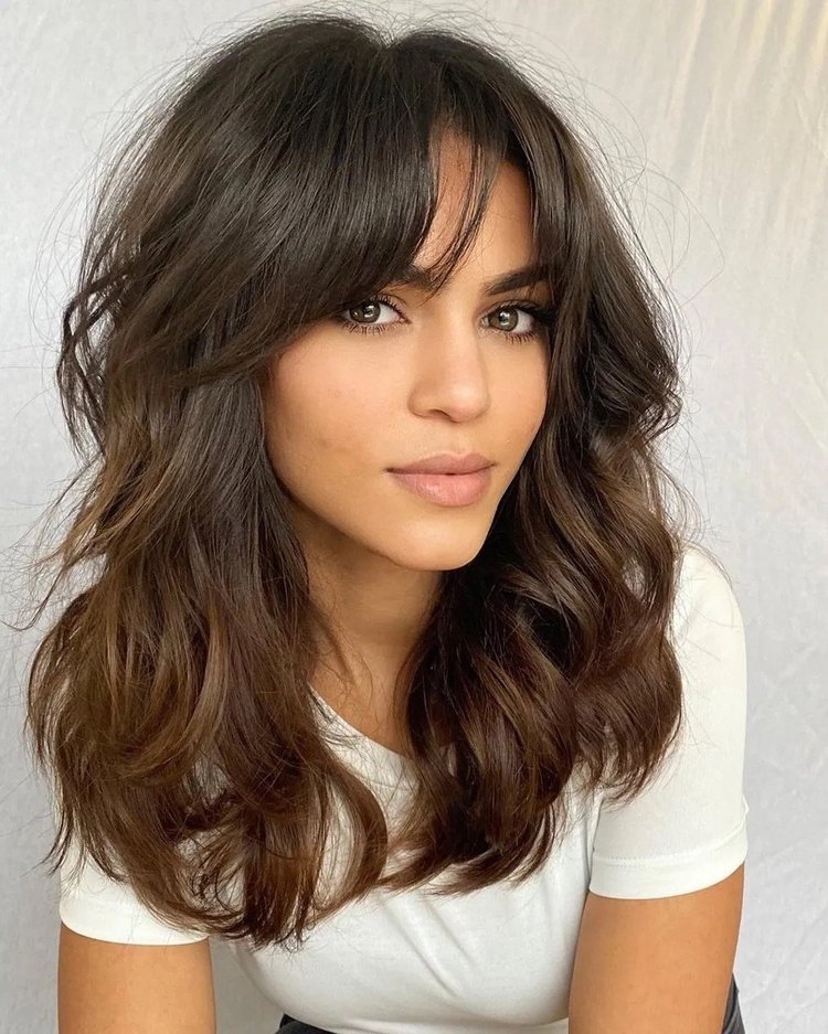 Brunette wavy shag haircut with curtain bangs