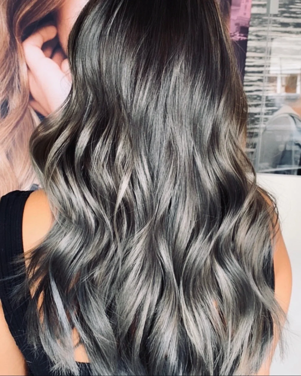 Long wavy hair with smoky gray balayage melting from dark roots