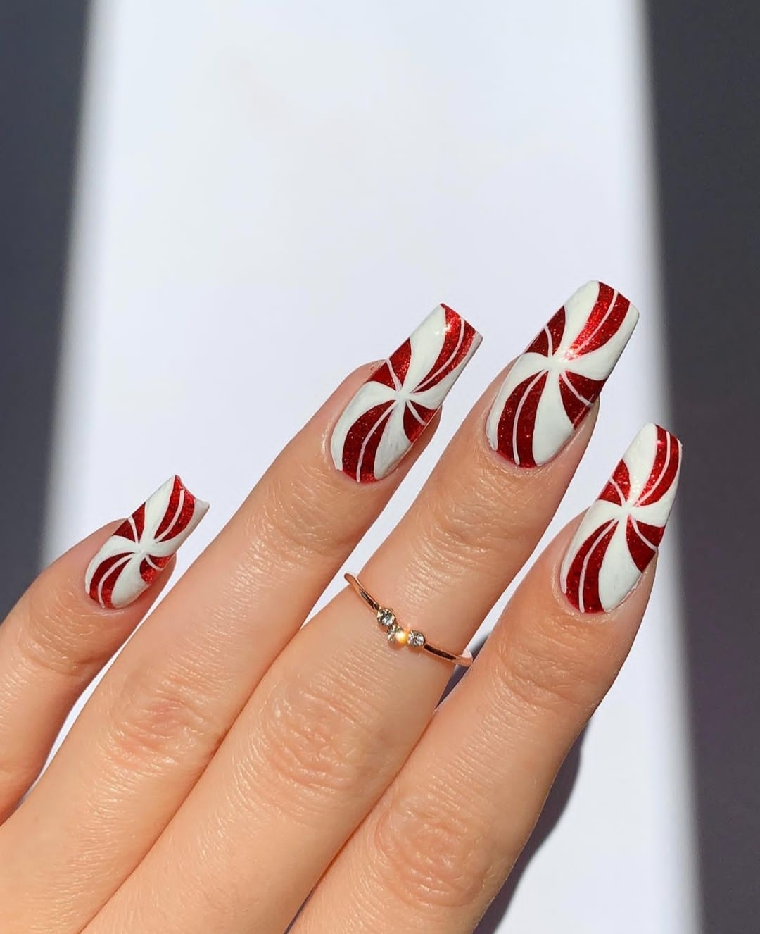 White long tapered nails with red peppermint pinwheel swirl art