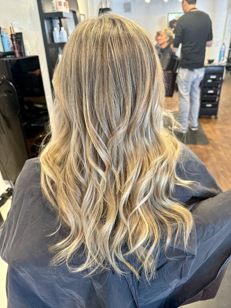 Layered waves in creamy blonde hair with cinnamon-brown lowlights, in salon