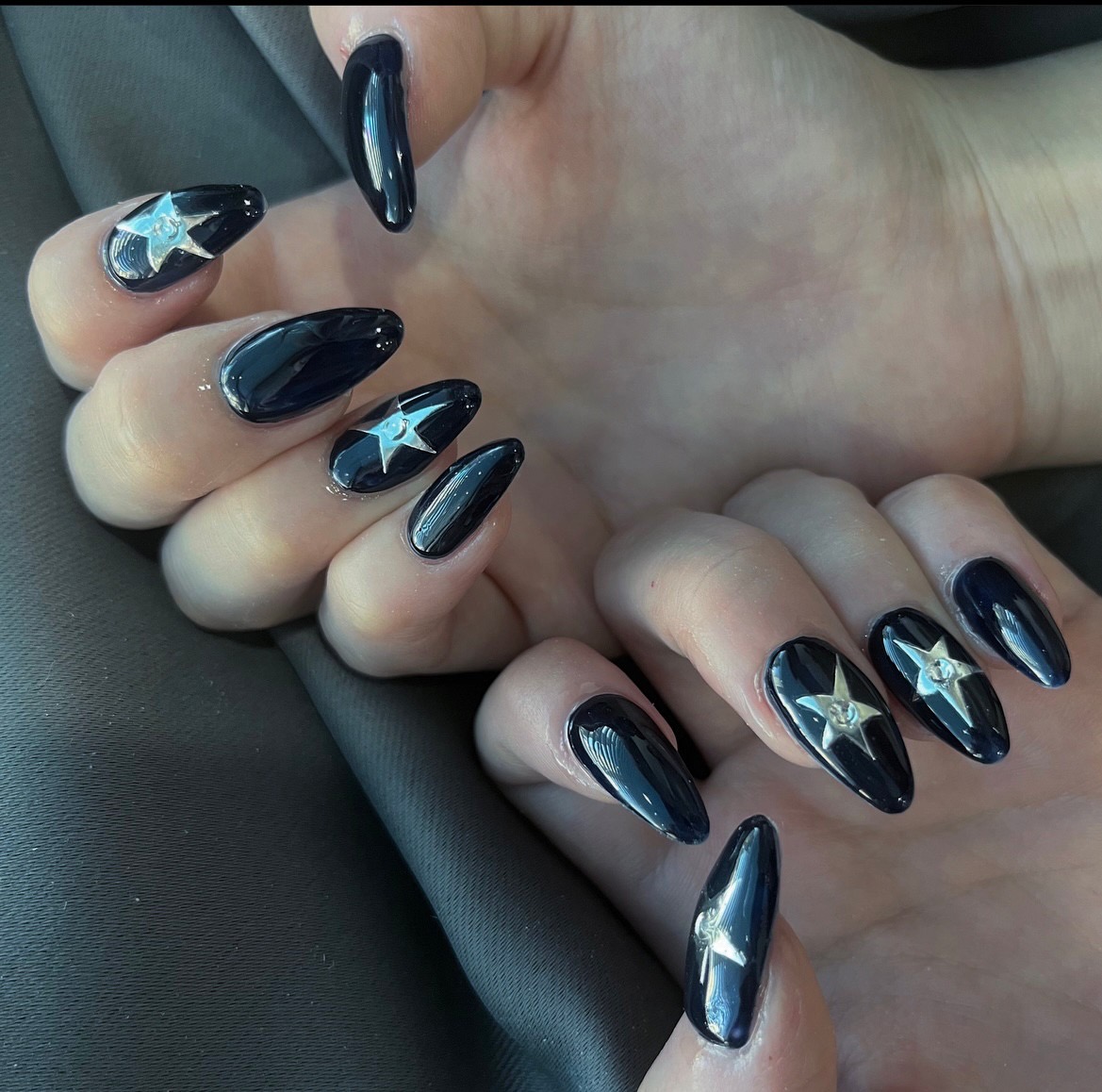 Midnight navy almond acrylic nails with large silver star nail art on accent nails