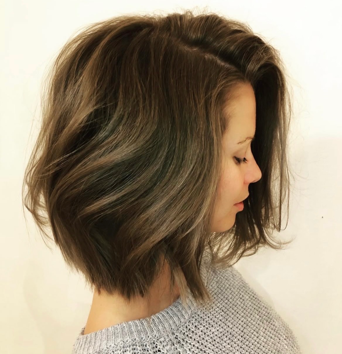 Woman with an ash-brown layered bob with soft airy waves