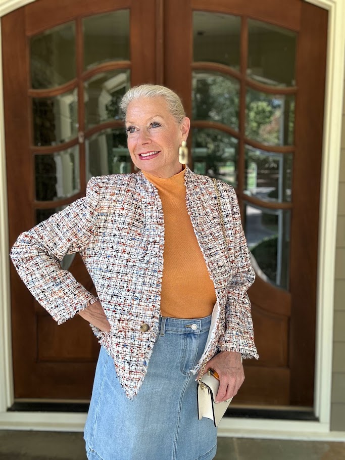 Mature woman in a navy tweed blazer with a cream crewneck sweater