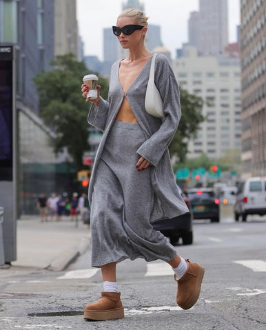 Woman wearing Ugg Disquette platform slides with a matching heather-grey sweatsuit