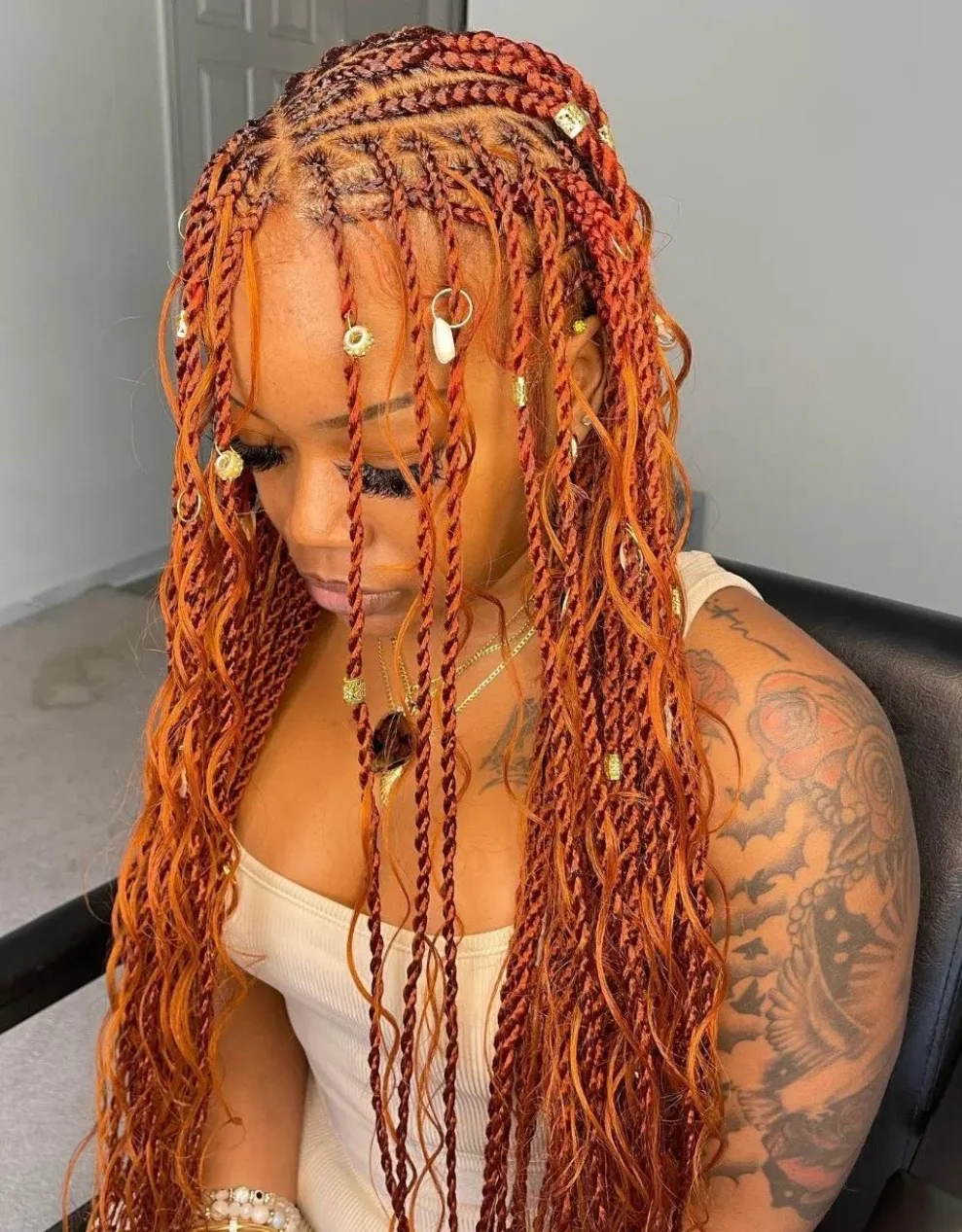 Copper boho braids with loose curls and gold hair rings
