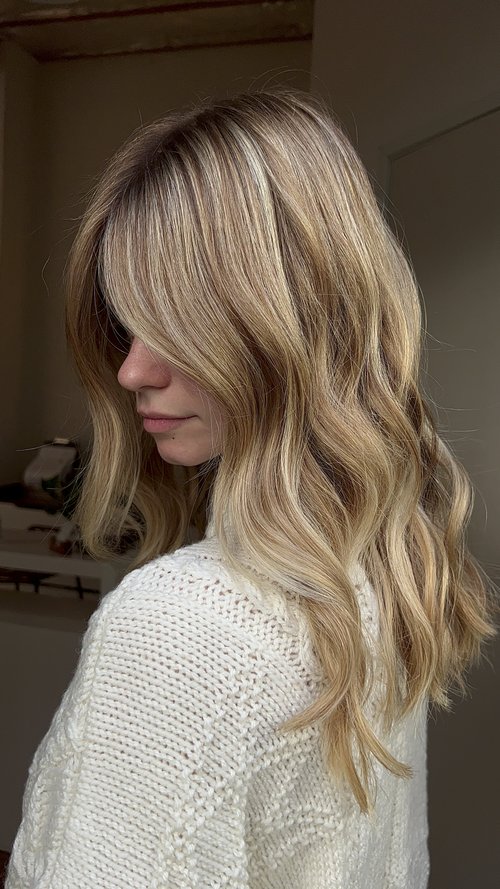 Medium-length wavy vanilla blonde hair with honey lowlights