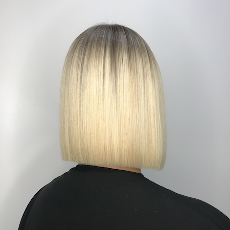 Straight blunt platinum bob with dark rooted lowlights, back view