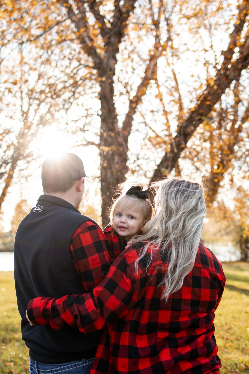 Family in matching plaid shirts outdoors in autumn