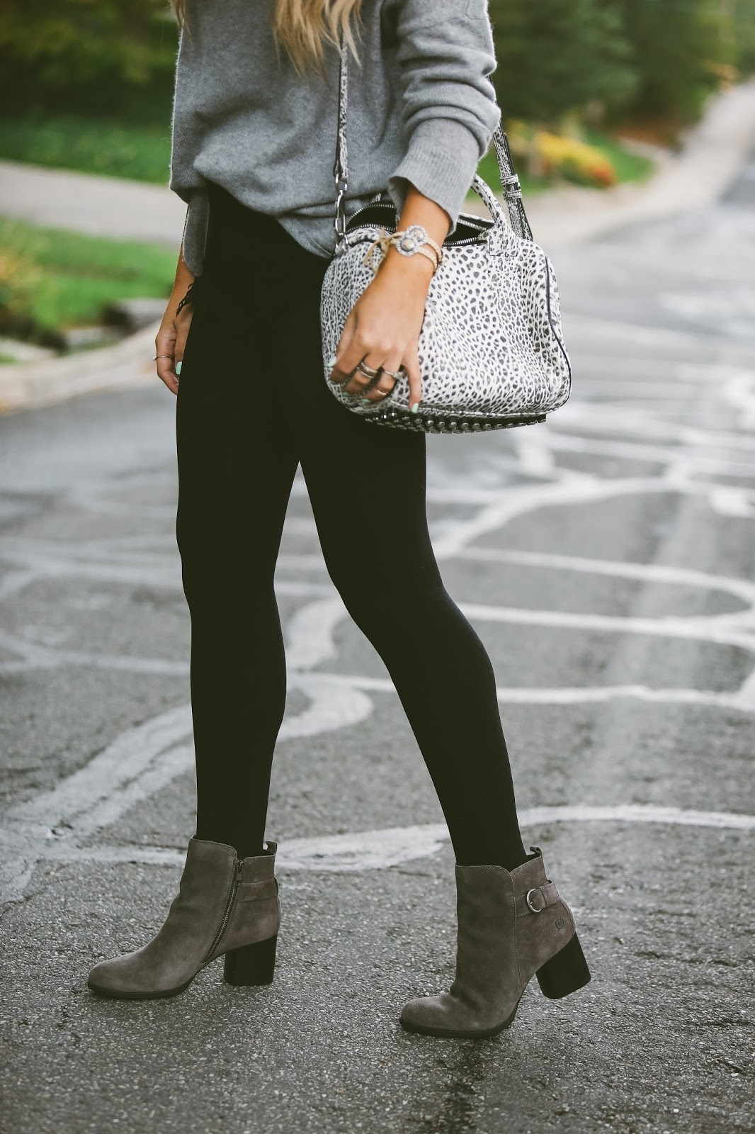 Woman in grey suede ankle boots, black leggings and an oversized grey sweater