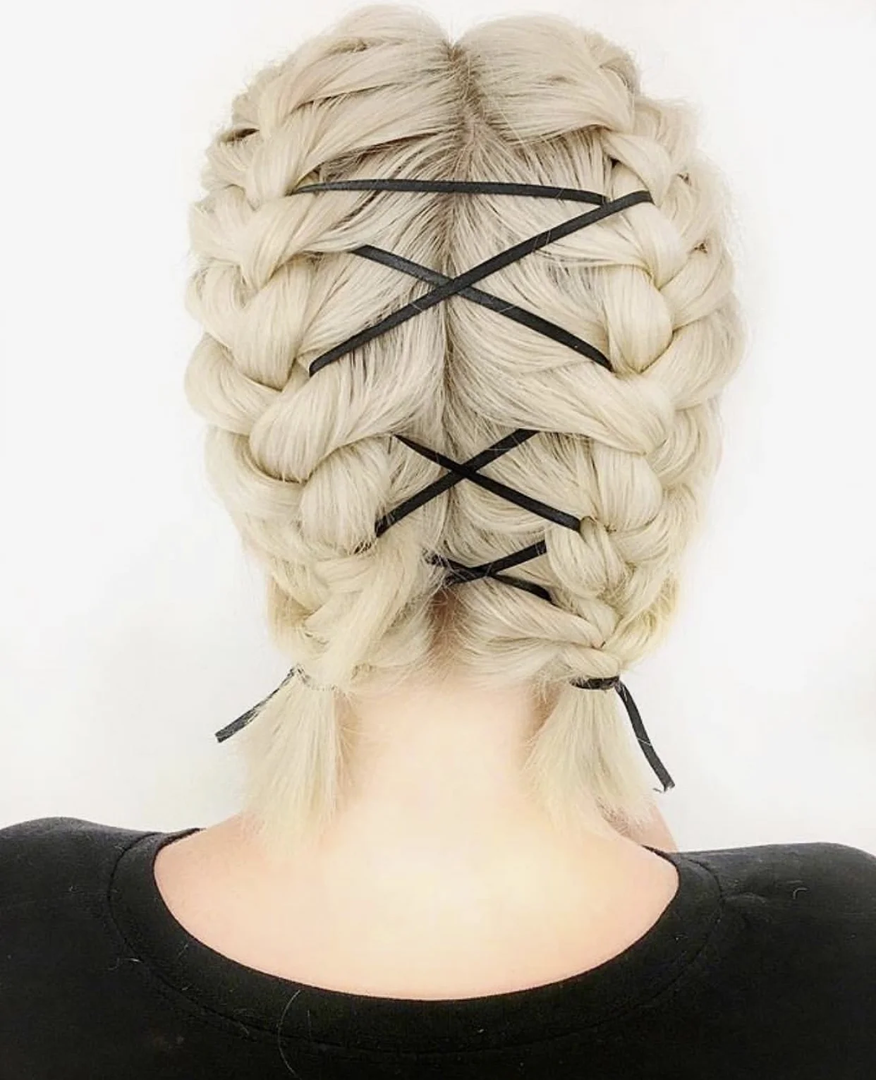 Woman with double Dutch braids laced with black ribbon