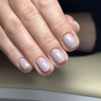Short square nails painted in solid greige nude polish